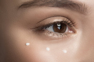 woman applying eye cream with finger